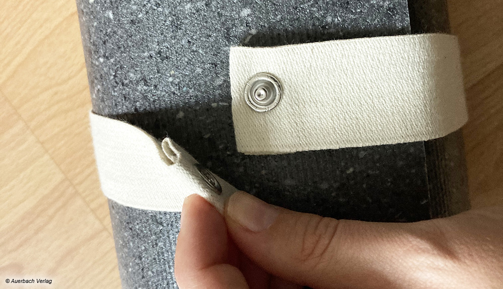 Praktisches Accessoire: Ein breites Baumwollband mit Druckknopf hält die Hejhej-Matte nach dem Einrollen fest zusammen