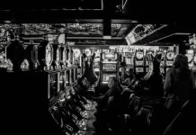 Mehrere Menschen zocken an Spielautomaten in einem Casino