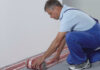 Handwerker installiert Fußbodenheizung von AEG