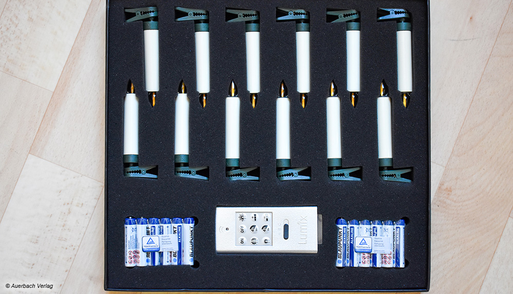 Krinner sortiert seine Kunstkerzen samt Batterien und Fernbedienung ordentlich in einen Lagerkarton. Hier sind die Kerzen sicher bis zum nächsten Fest 
