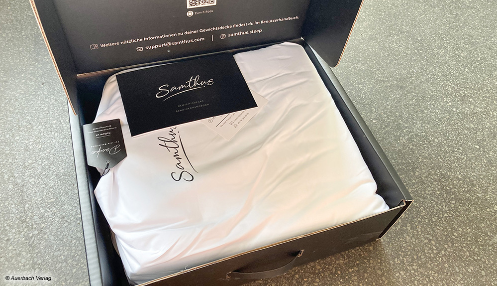 Das ist die schwarze Geschenkbox, in der die Gewichtsdecke von Samthus inklusive Tragebeutel aus Stoff geliefert wird
