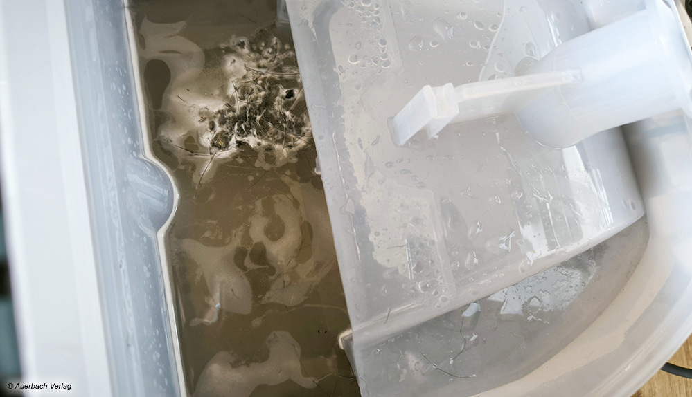 Ein Blick unter die Haube beim Kärcher legt den Blick auf den Wassertank frei: Hier wird der aufgesaugte Schmutz gesammelt
