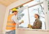 Handwerker bauen Fenster ein