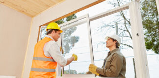 Handwerker bauen Fenster ein